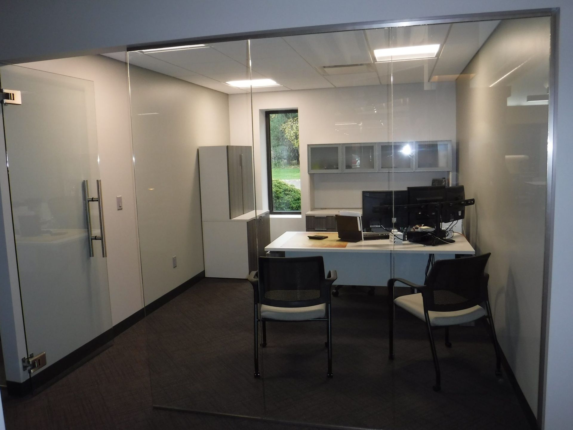 A small office with a desk and chairs.