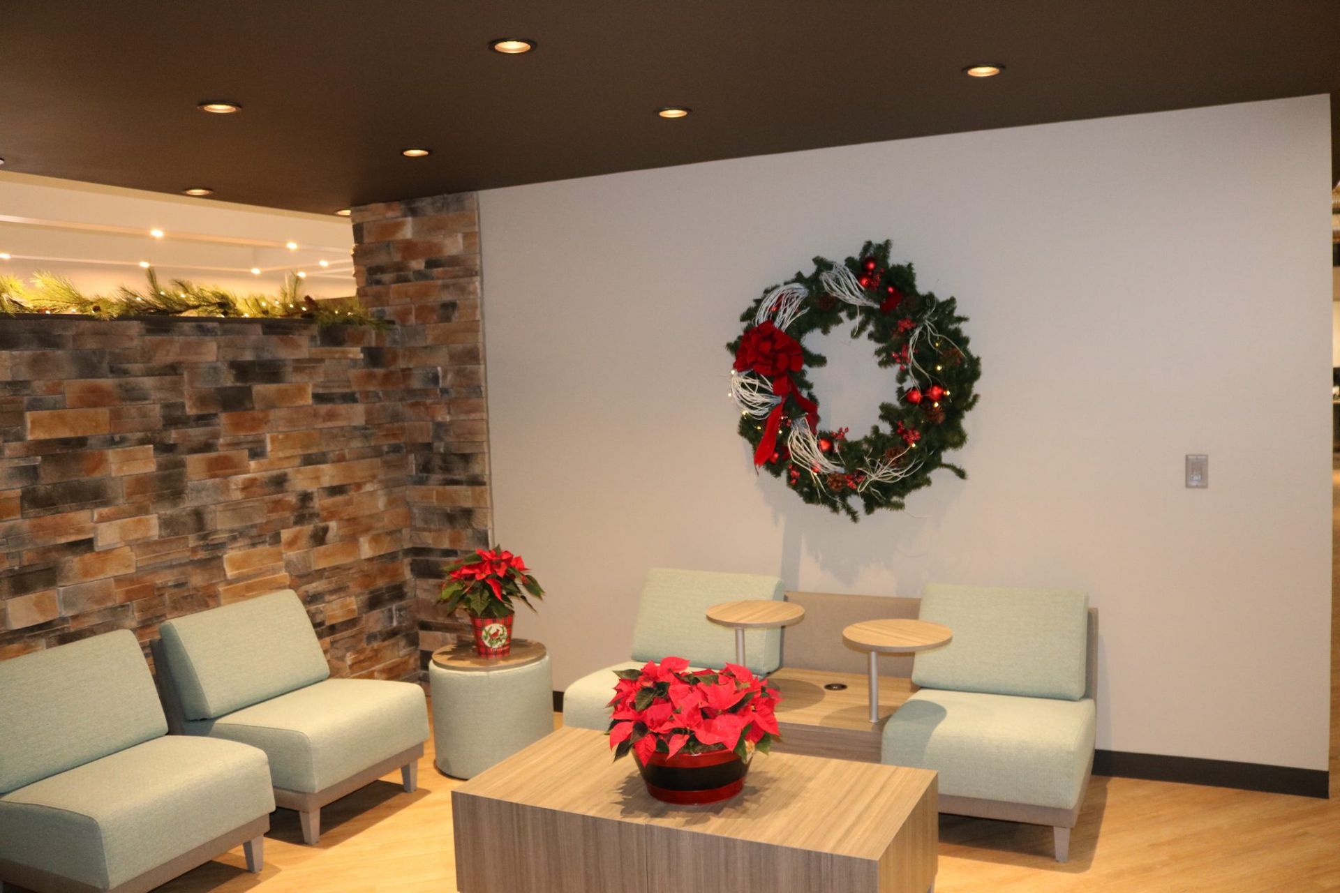A waiting room with chairs and a wreath on the wall.