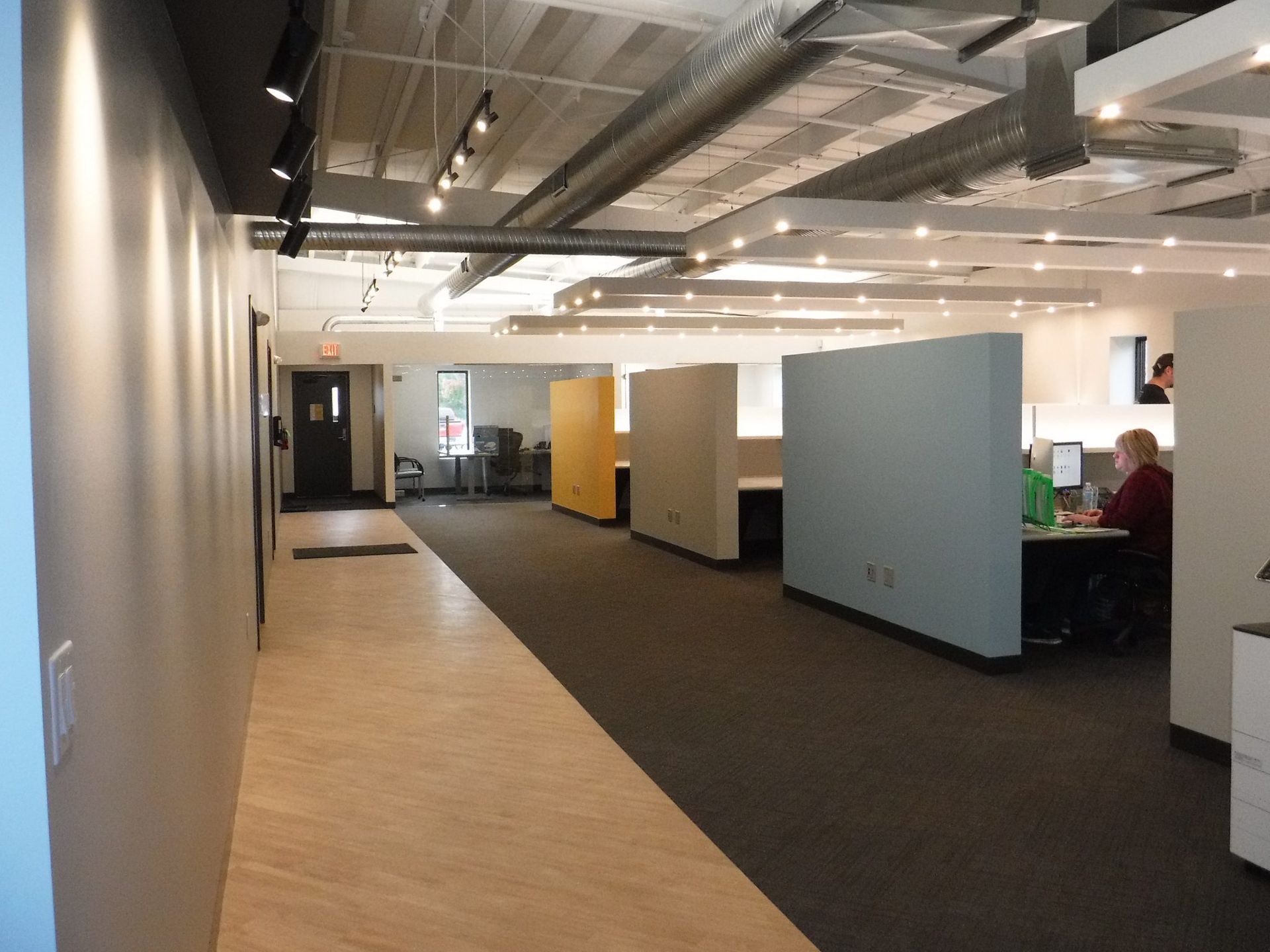 A man sits at a desk in a large office.