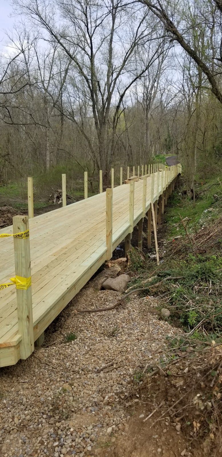 A wooden bridge is being built in the middle of a forest.