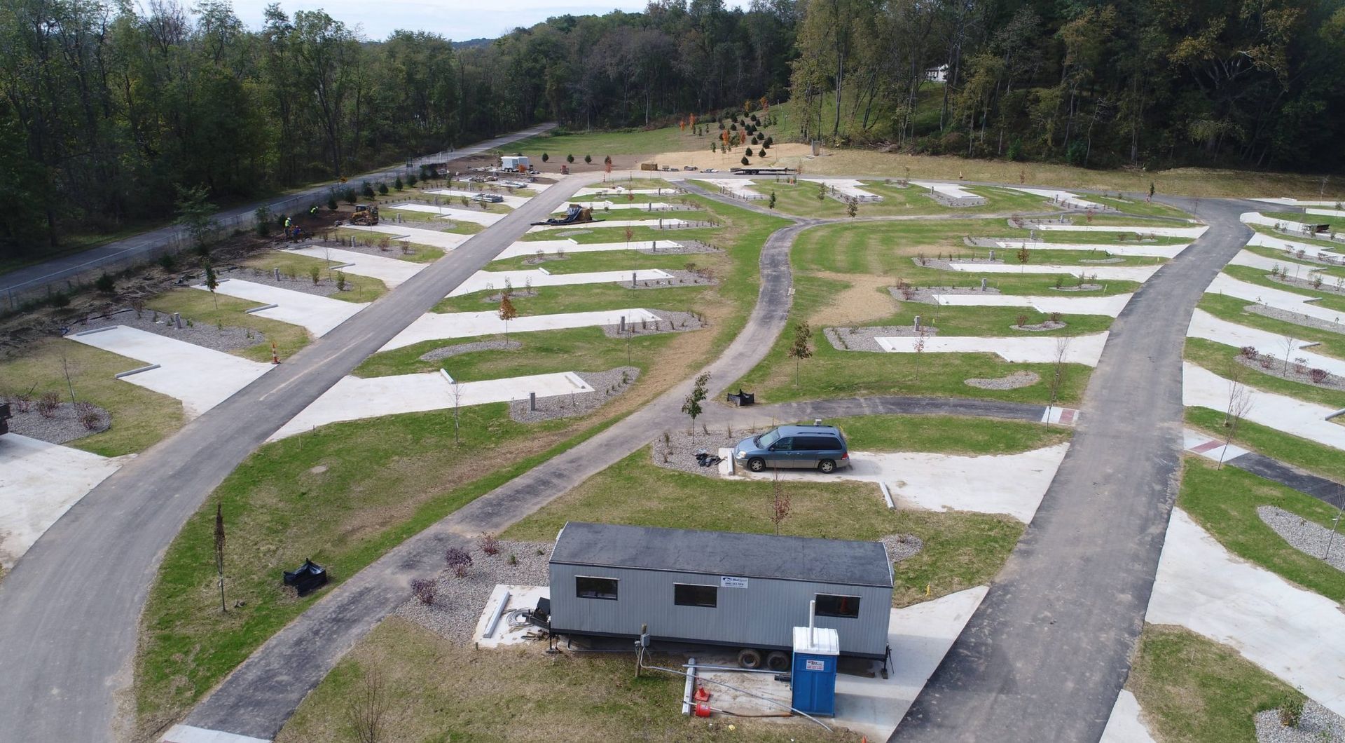 An aerial view of a campground with a trailer parked in the middle of it.