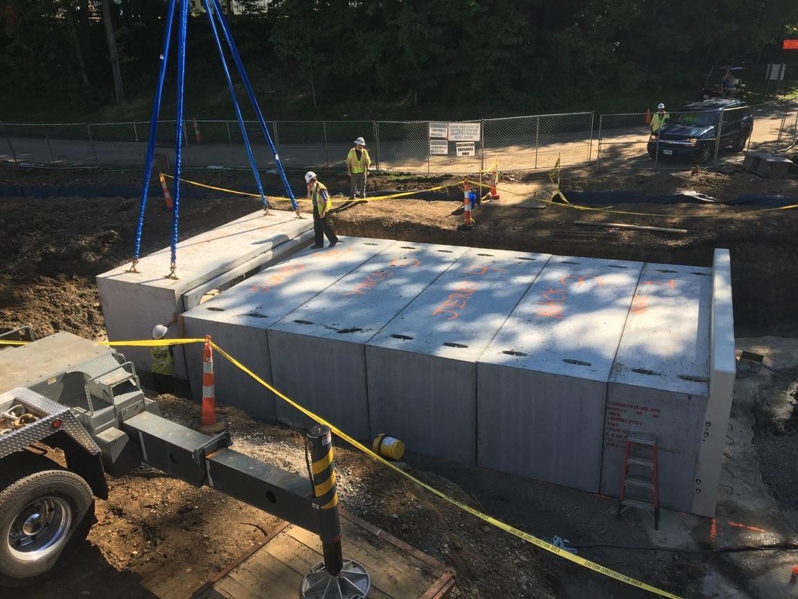 A group of construction workers are working on a large concrete structure.