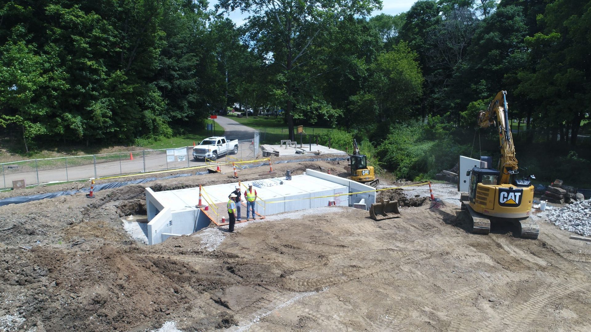 A construction site with a cat excavator in the middle of it.
