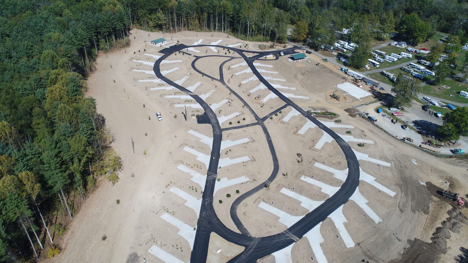 An aerial view of a dirt road surrounded by trees.