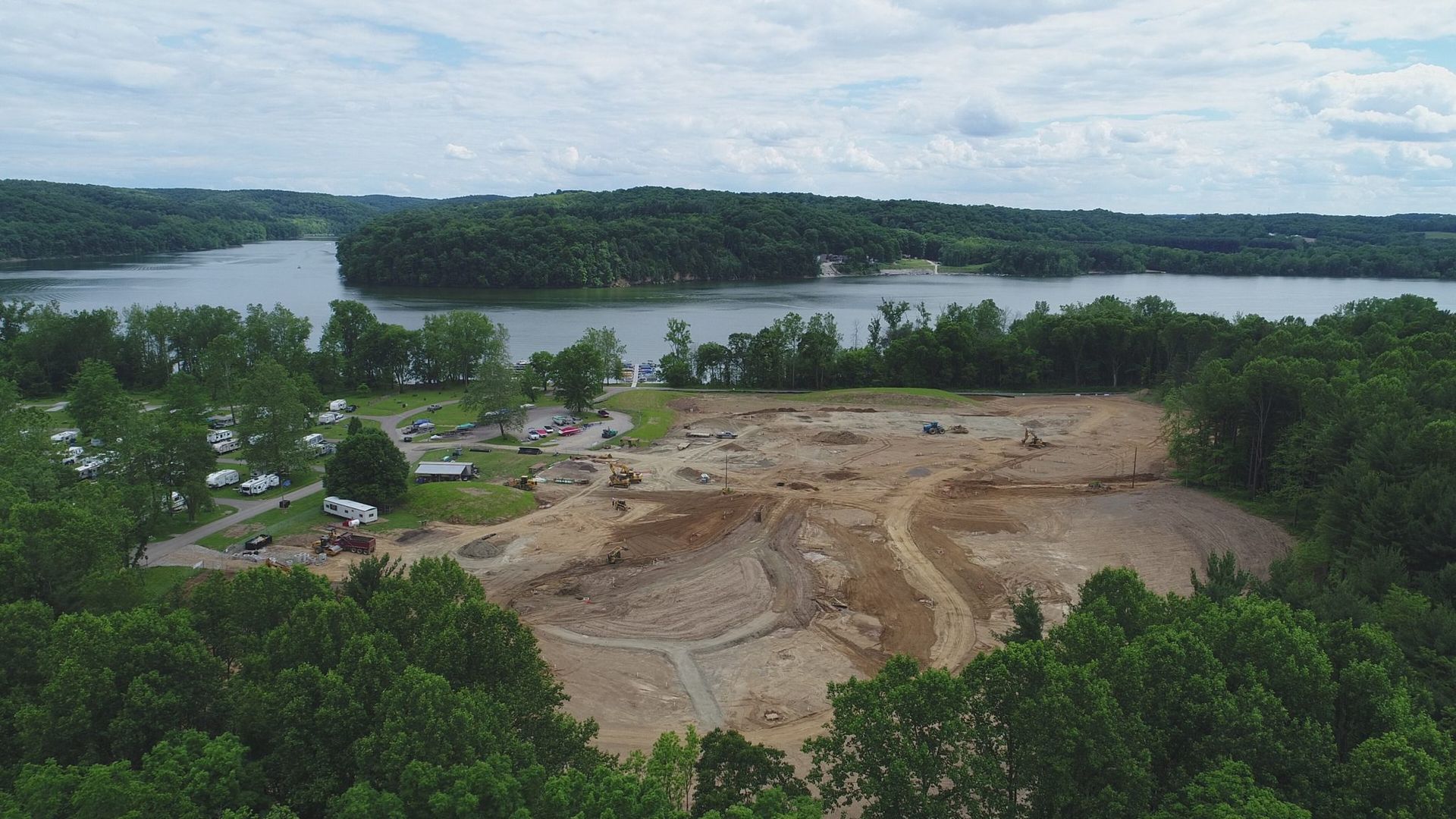 An aerial view of a construction site next to a lake.
