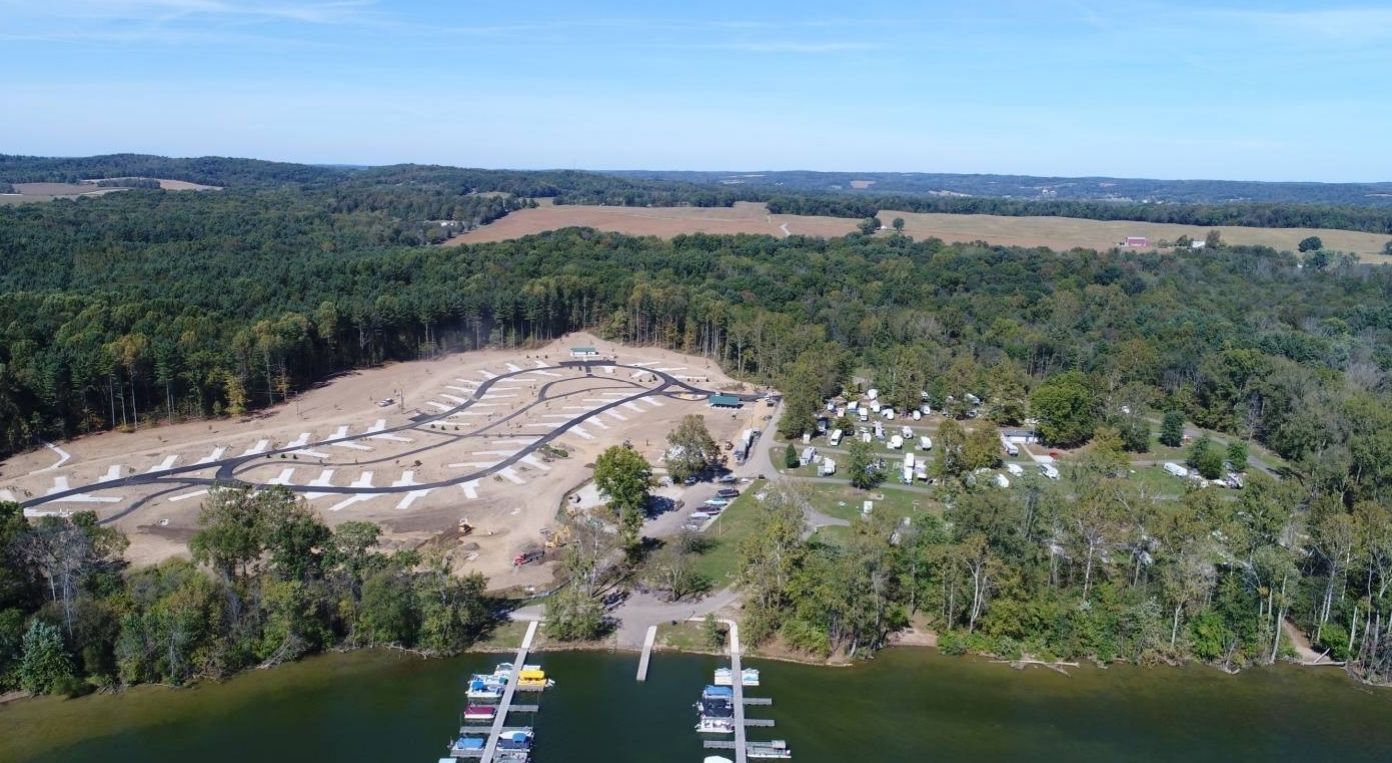 An aerial view of a marina surrounded by trees and a lake.