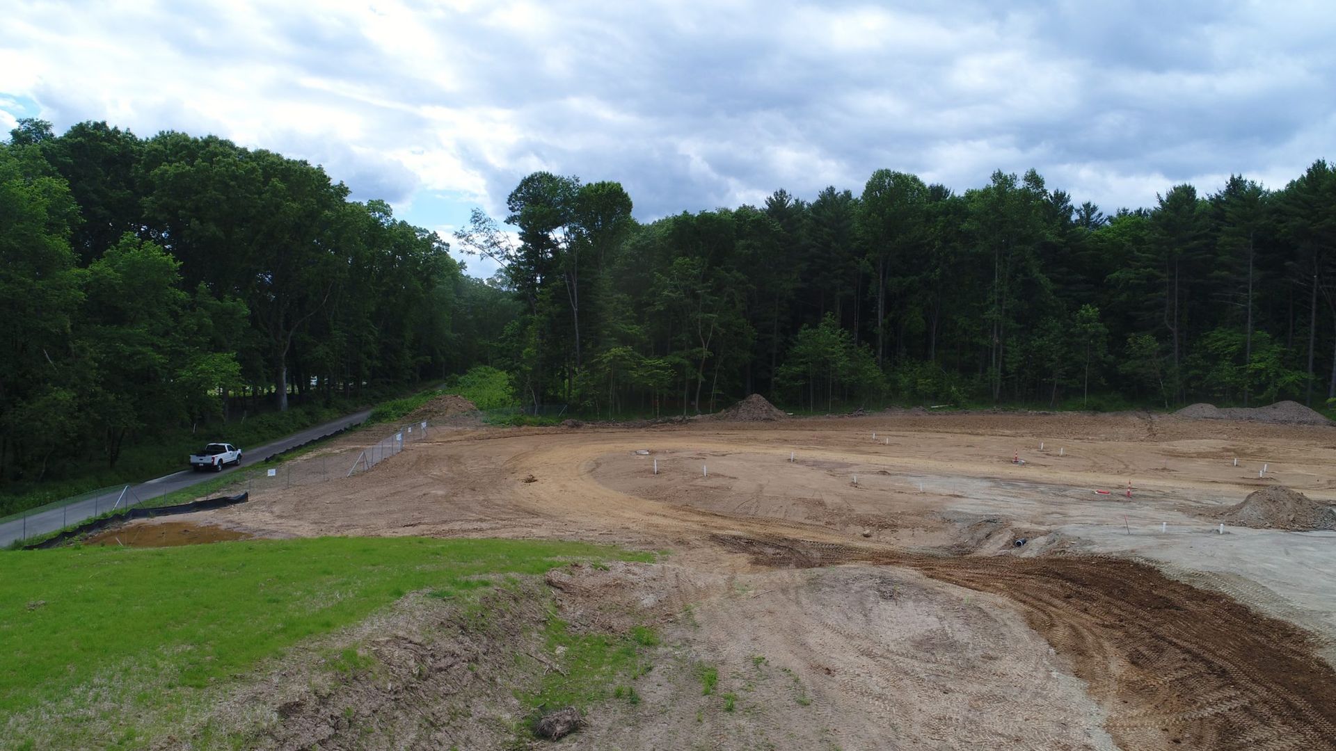 An aerial view of a dirt field with trees in the background.