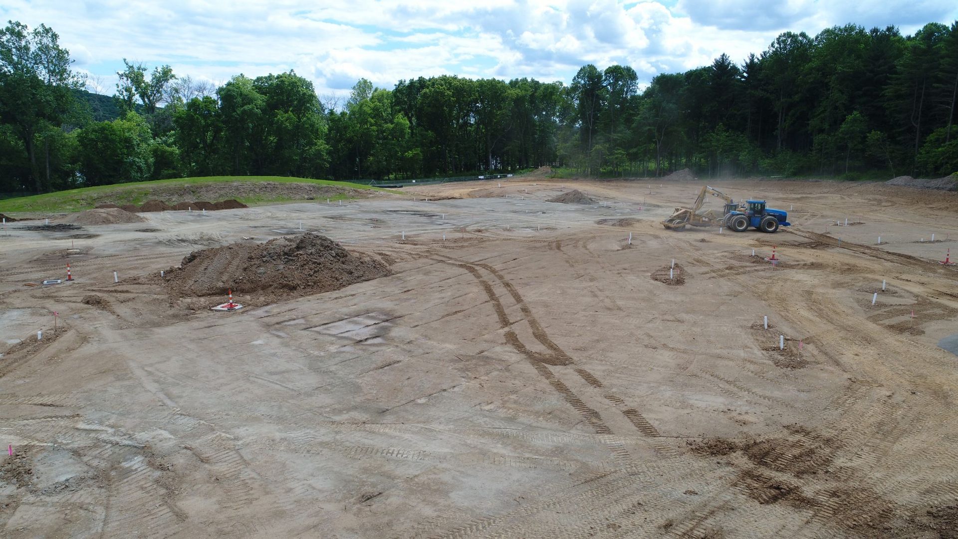 A large dirt field with trees in the background.