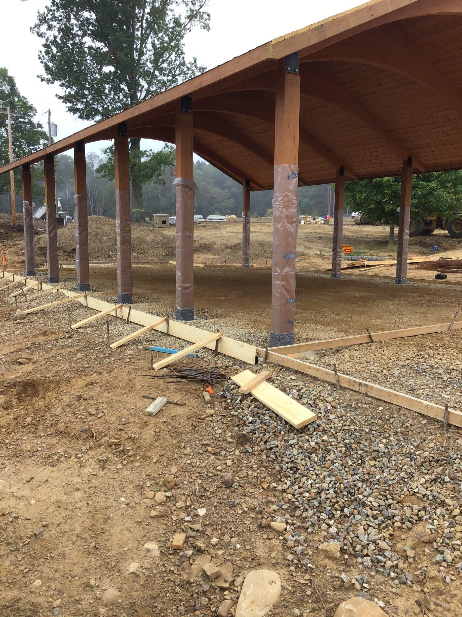 A wooden structure is being built in the middle of a dirt field.