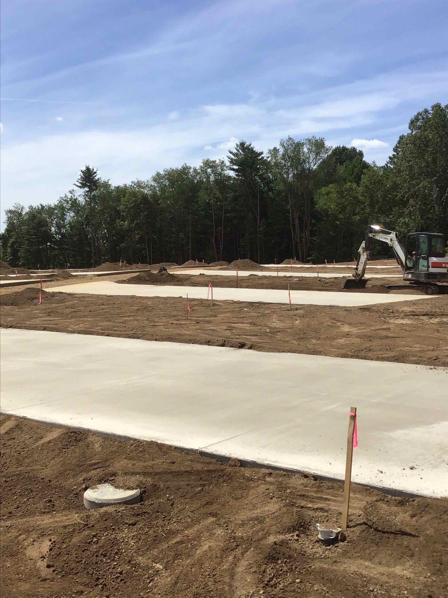 A construction site with a lot of dirt and trees in the background.