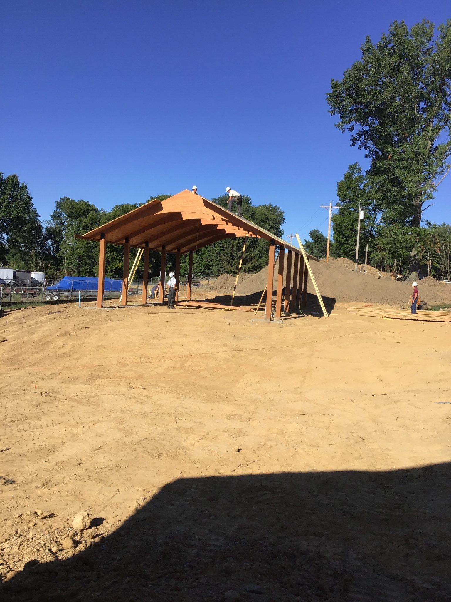 A wooden structure is being built in the middle of a dirt field.