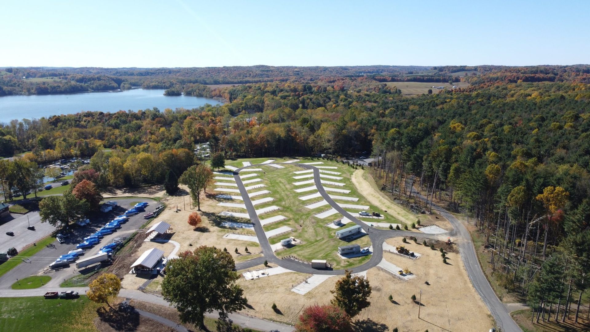 An aerial view of a campground with a lake in the background.