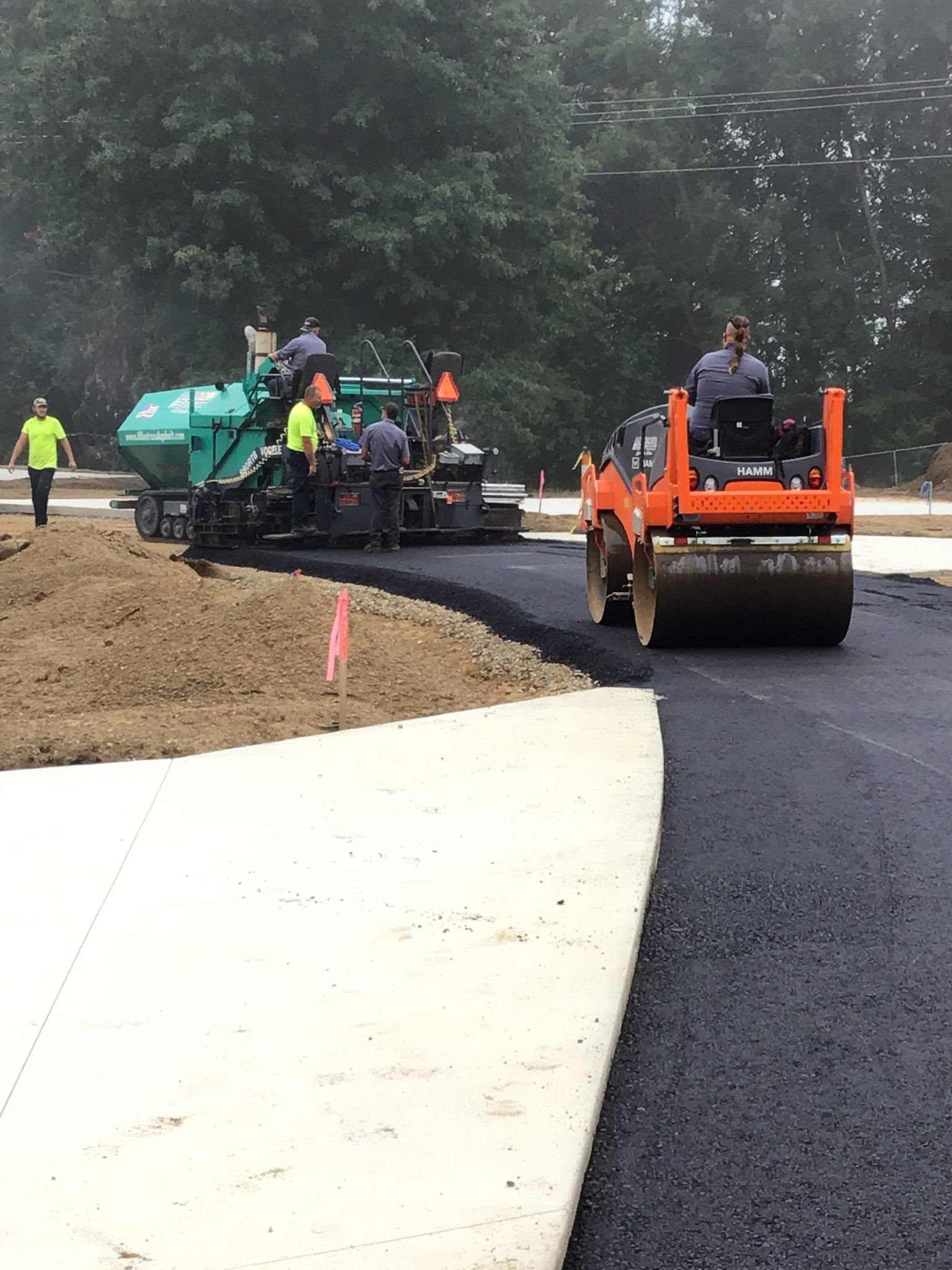 A group of construction workers are working on a road.