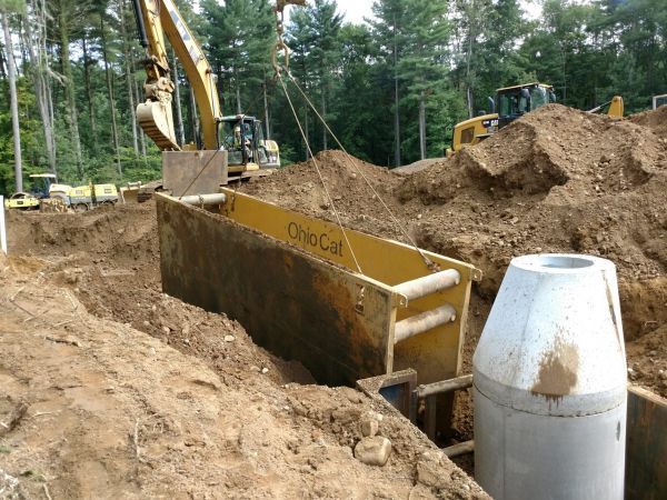 A yellow excavator is digging a hole in the dirt.