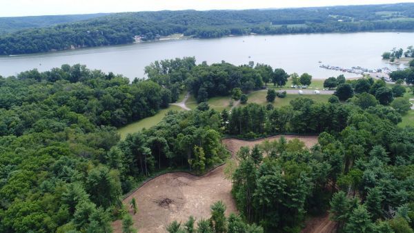 An aerial view of a lake surrounded by trees and grass.