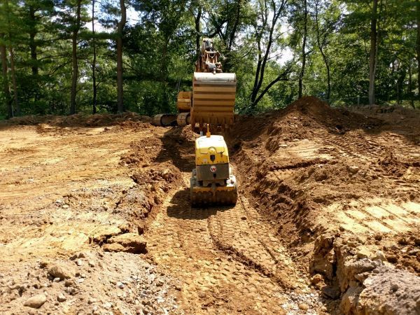 A bulldozer is driving through a dirt field.