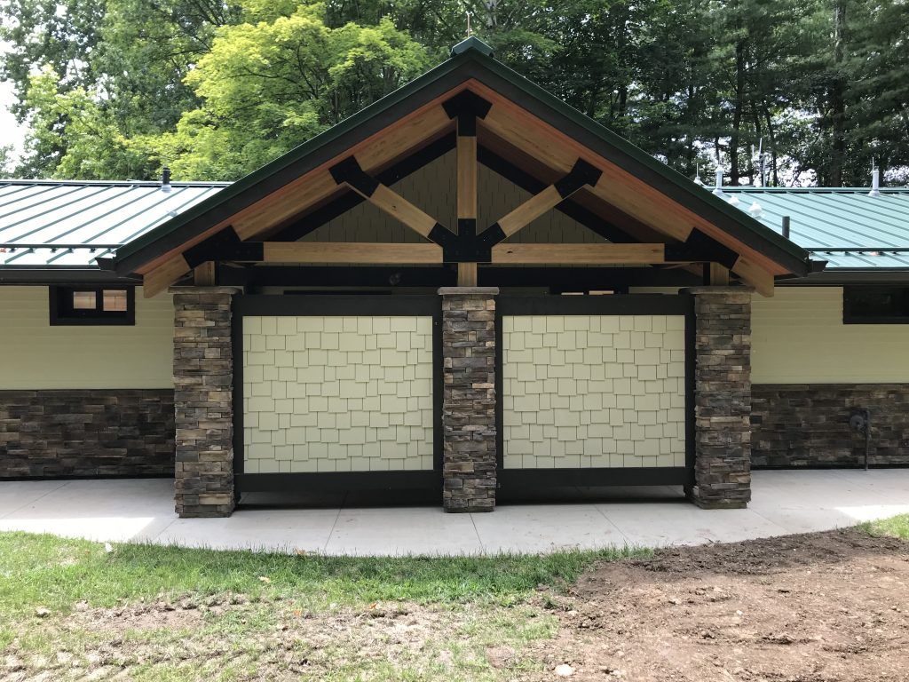 A building with a green roof and a stone wall.