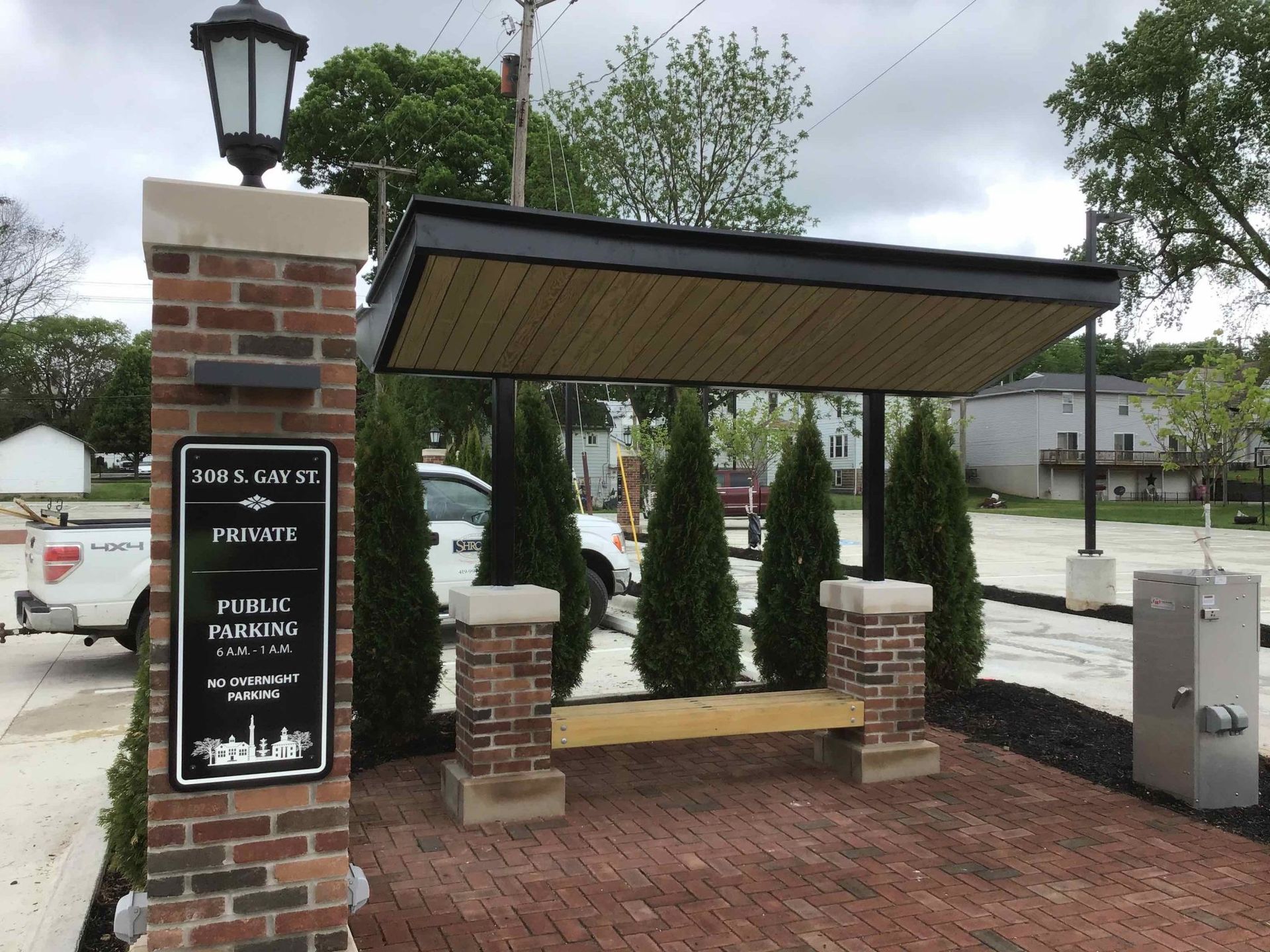 A brick pillar with a sign on it that says public parking.