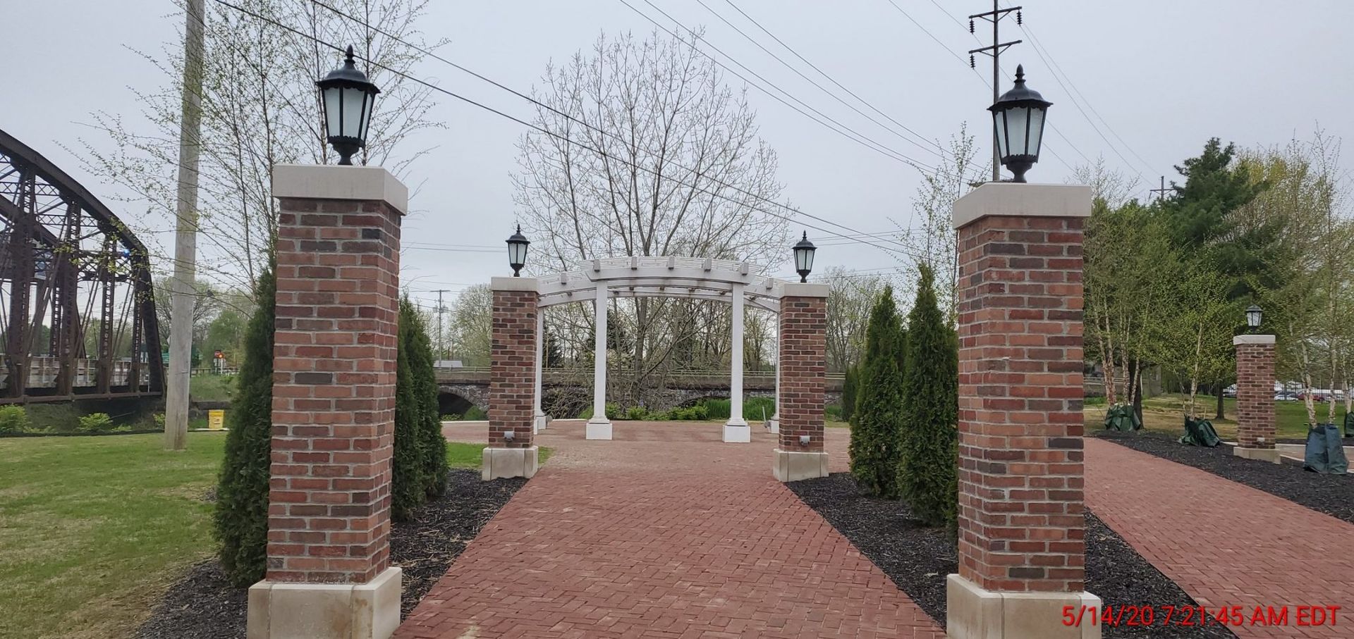 A brick walkway with a gazebo in the background.