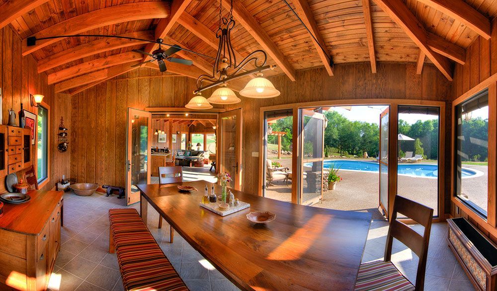 A dining room with a large wooden table and chairs