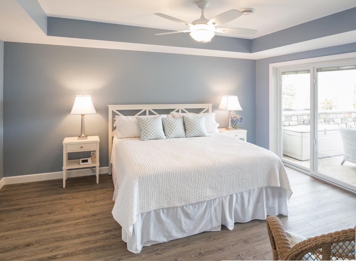 A bedroom with a king size bed and a ceiling fan.