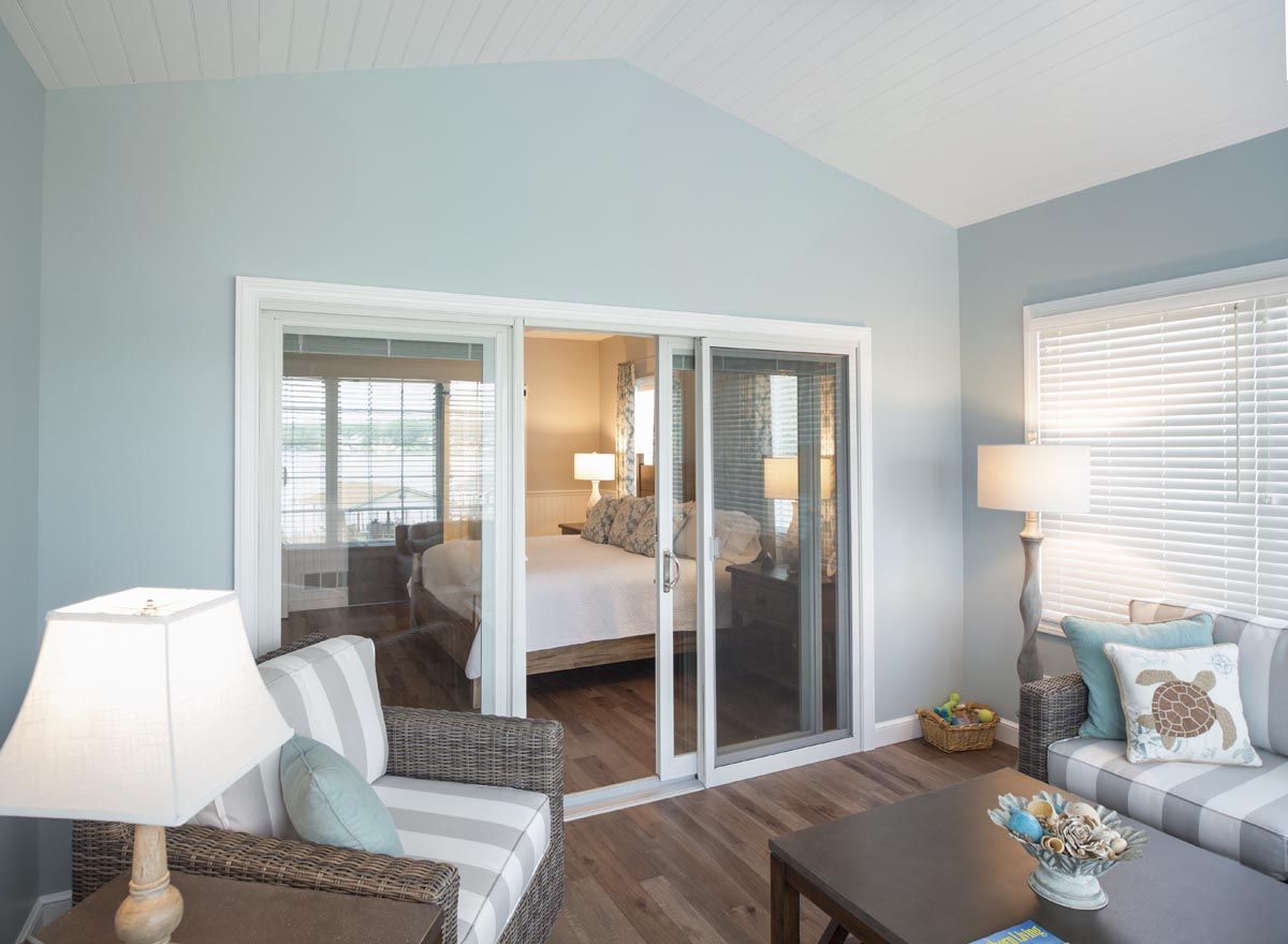 A living room with sliding glass doors leading to a bedroom.