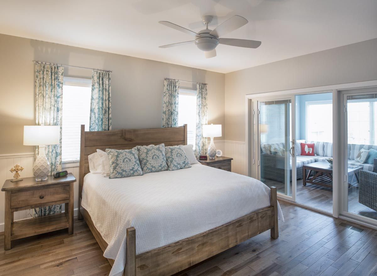 A bedroom with a king size bed and a ceiling fan.