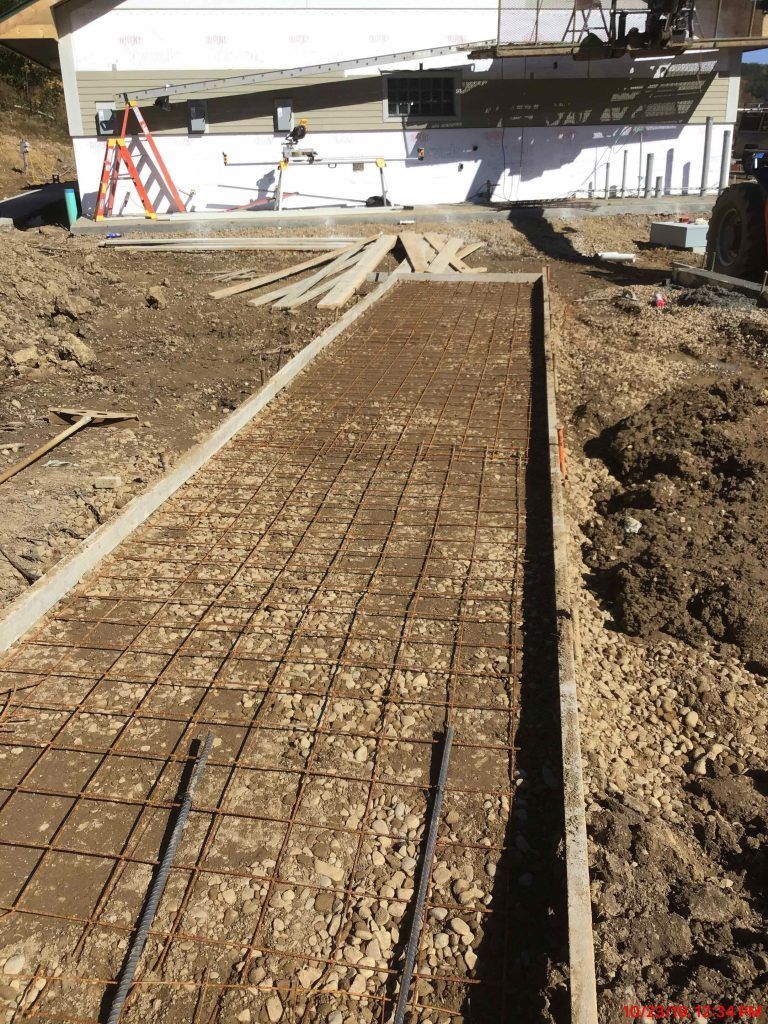A concrete walkway is being built in a dirt field.
