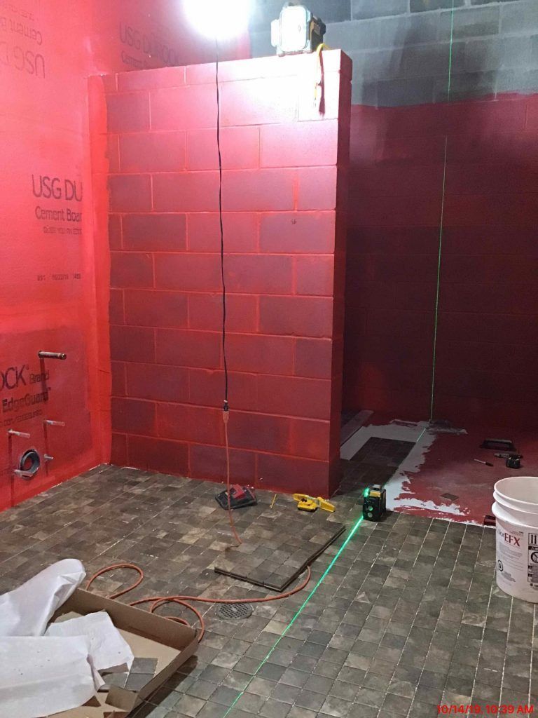 A bathroom with red brick walls and a green laser.