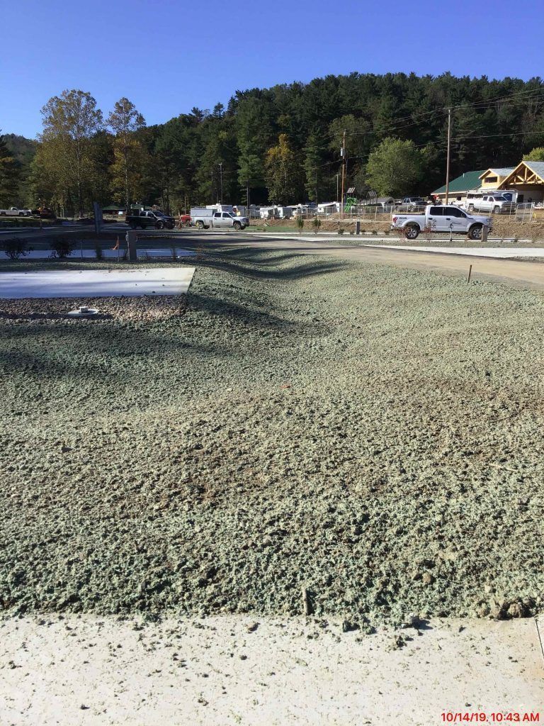 A lot of gravel is laying on the ground in a parking lot.