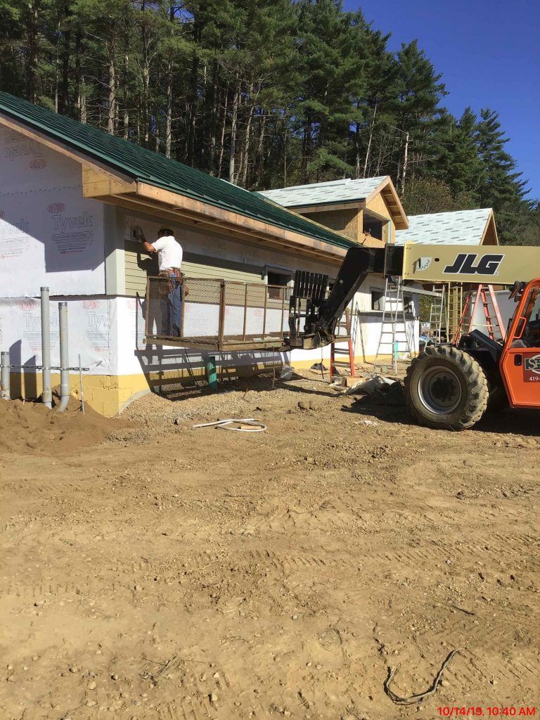 A jlg forklift is parked in front of a building under construction.