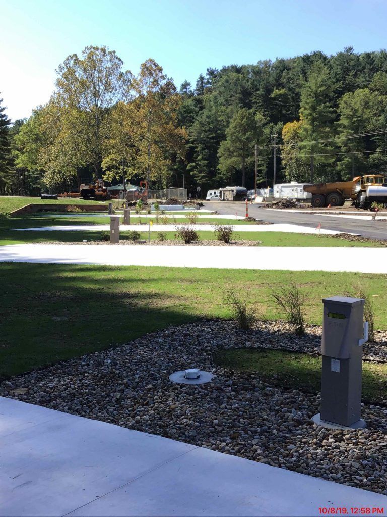 An RV park with a lot of grass and trees.