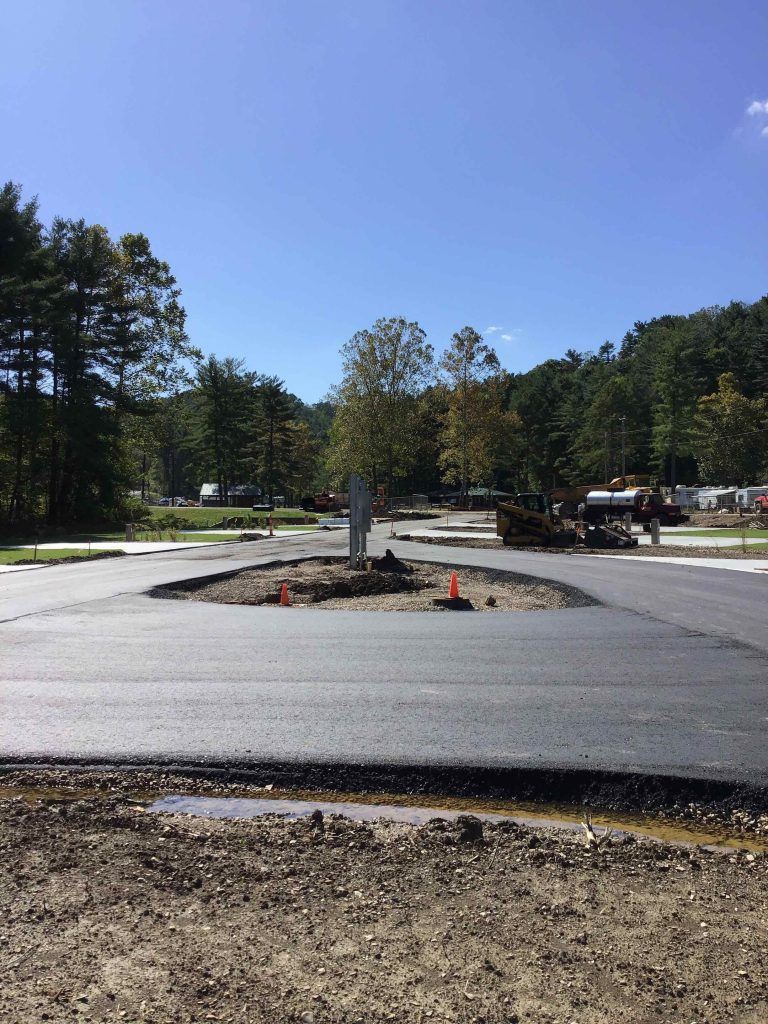 A construction site with a lot of dirt and trees in the background.