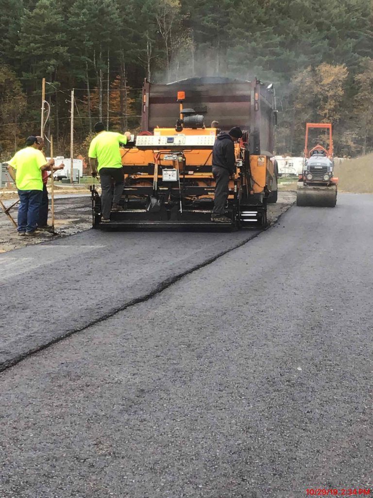 A group of construction workers are working on a road.