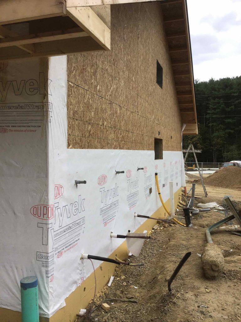 A house is being built with a lot of insulation on the side of it.