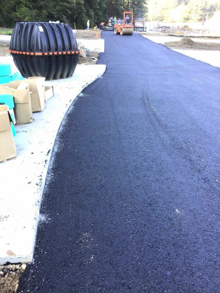 A large black tank is sitting on the side of a road.