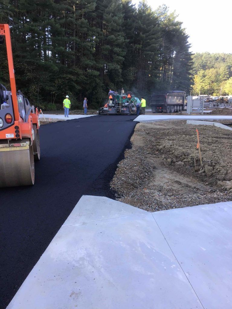 A group of construction workers are working on a road.