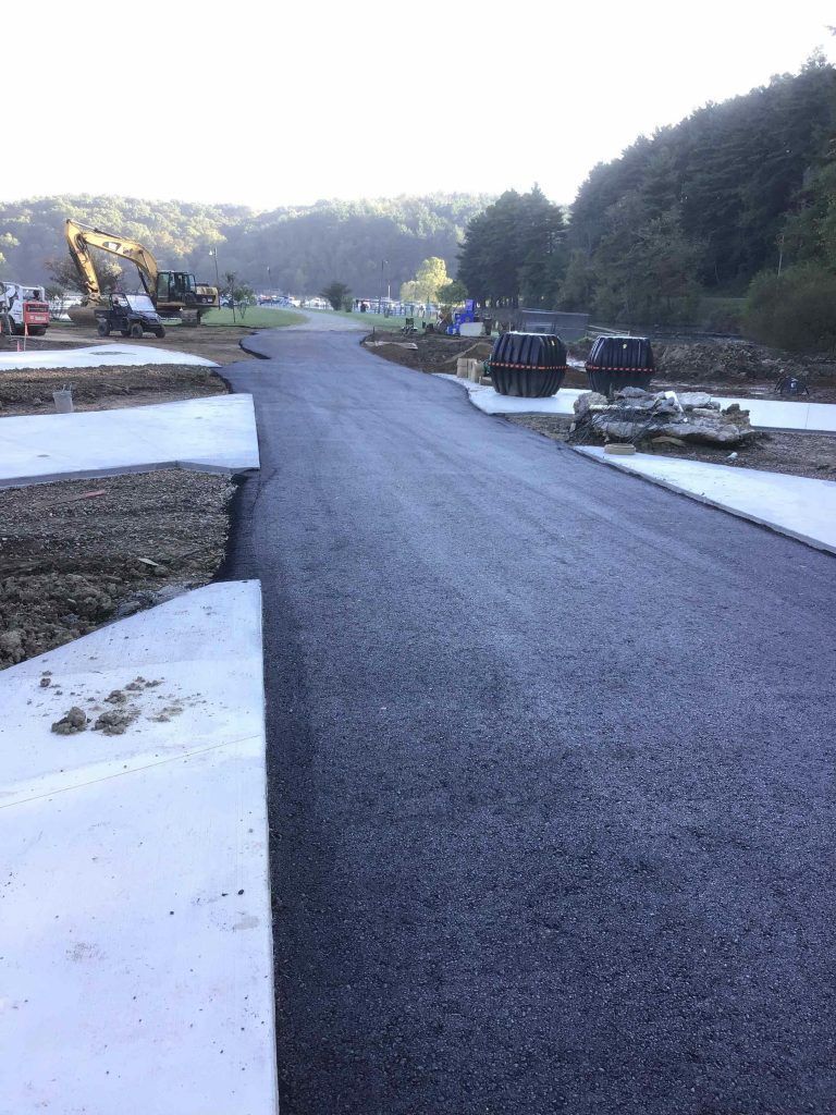 A road is being built in a field with trees in the background.