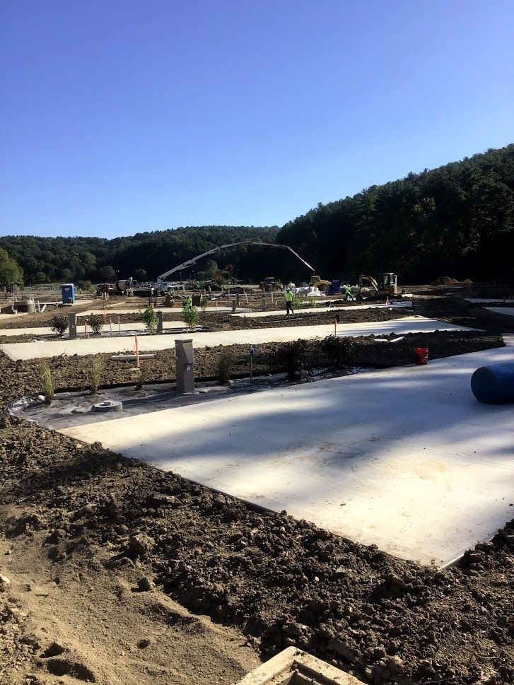 A construction site with a lot of dirt and trees in the background.