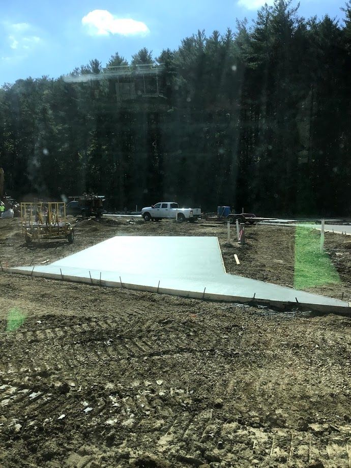 A concrete driveway is being built in the middle of a dirt field.