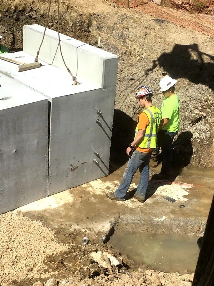 A group of construction workers are working on a large concrete block.