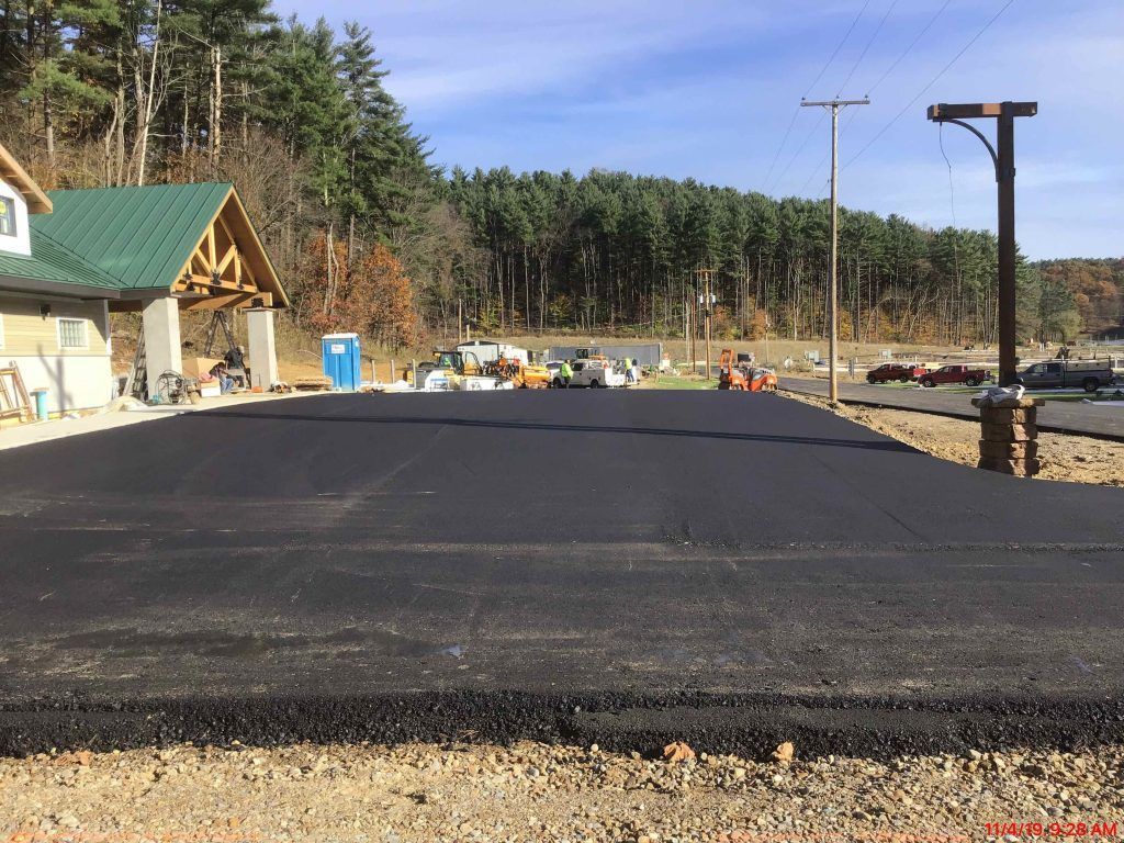A road that is being built with a house in the background.