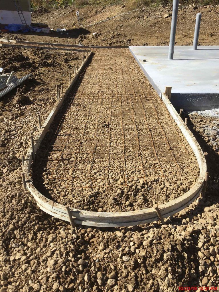 A concrete curb is sitting on top of a pile of gravel.