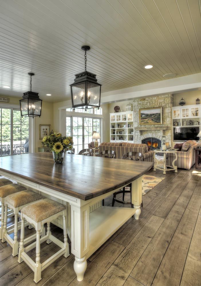 A kitchen with a large wooden table and stools.