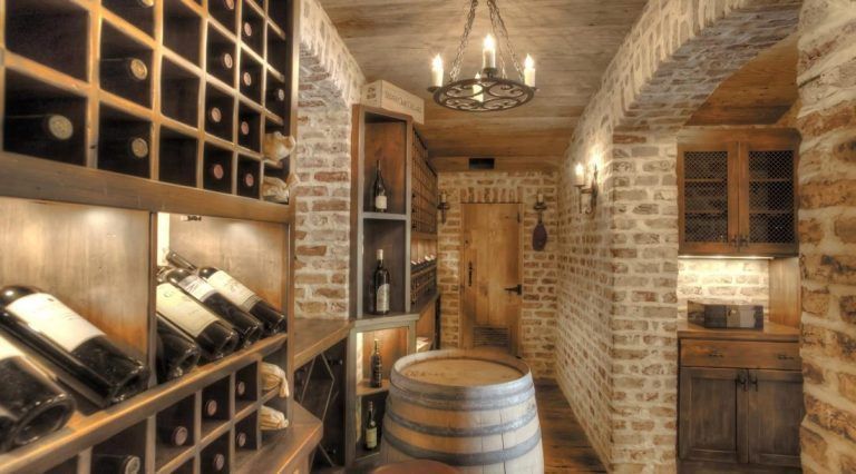 A wine cellar filled with bottles of wine and a wooden barrel.