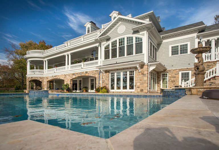 A large house with a swimming pool in front of it.