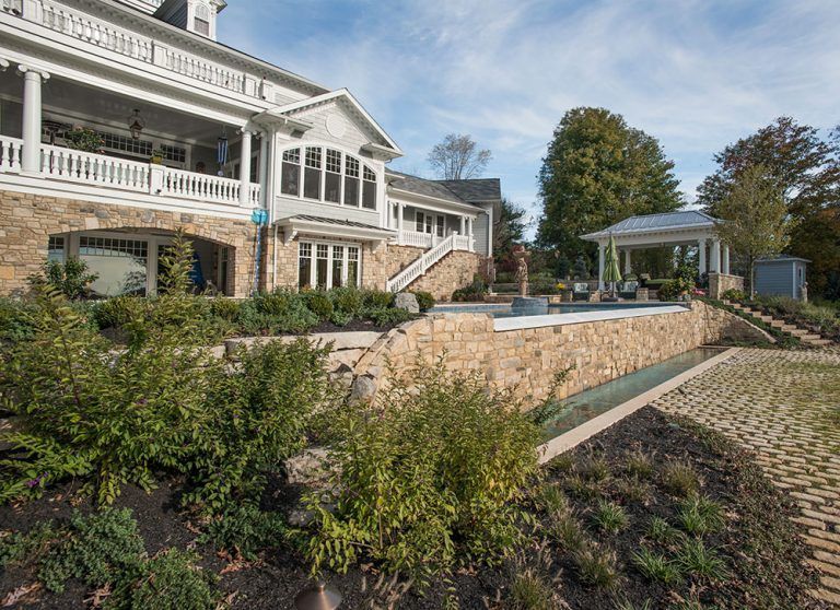 A large white house with a swimming pool in the backyard.