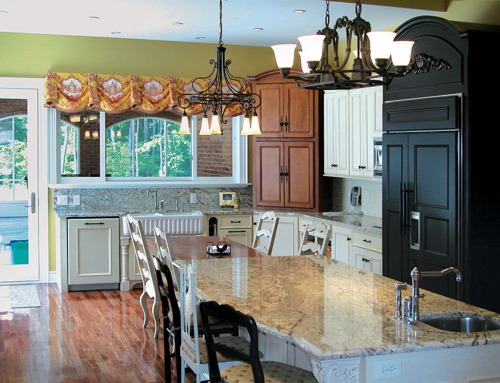 A kitchen with granite counter tops and white cabinets.
