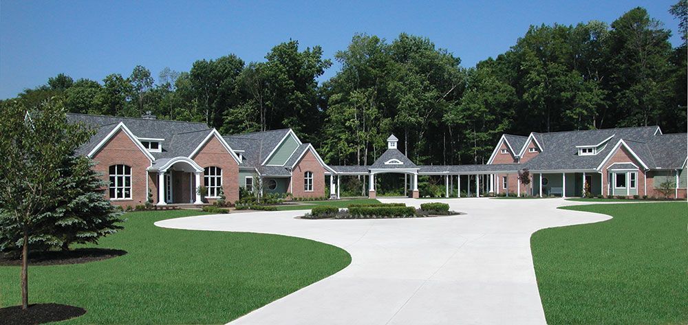 A large brick house with a driveway leading to it.