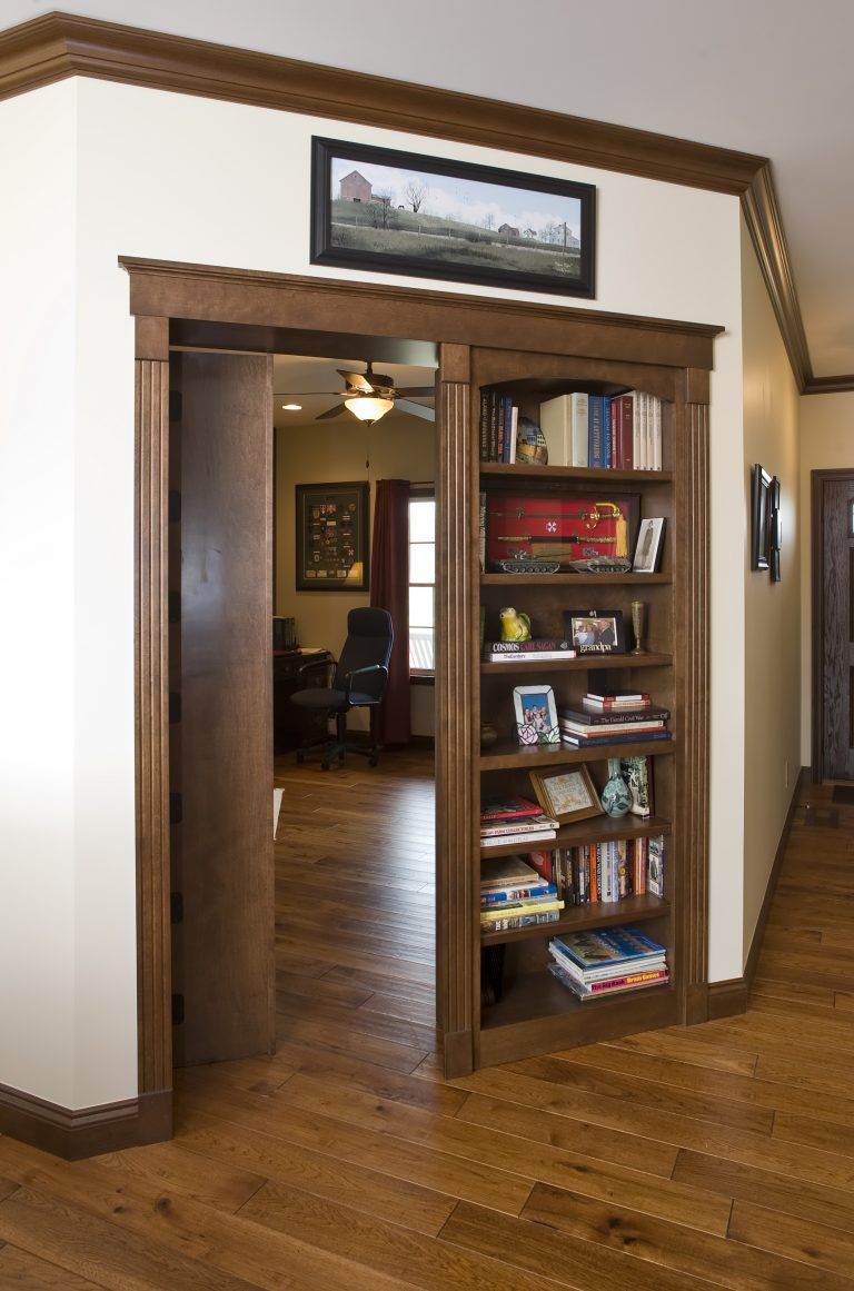A bookcase in a hallway leading to a living room.